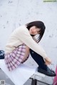 A young woman sitting on top of a white bench.