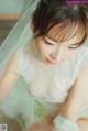 A woman in a wedding dress with a veil over her head.