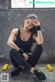A woman sitting on the ground with yellow dumbbells.
