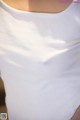 A close up of a woman wearing a white shirt.