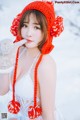 A woman wearing a red hat and gloves in the snow.