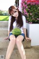 A woman sitting on the steps holding a watermelon.