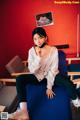 A woman sitting on a blue couch in a room.