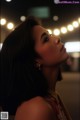 A woman with long black hair looking up at the sky.