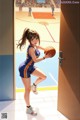 A woman holding a basketball in front of a door.