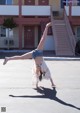 A woman doing a handstand in front of a building.