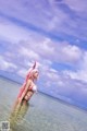 A woman in a bikini standing in the ocean.