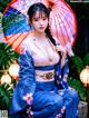 A woman in a blue kimono holding an umbrella.