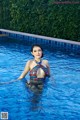 A woman in a bikini standing in a swimming pool.